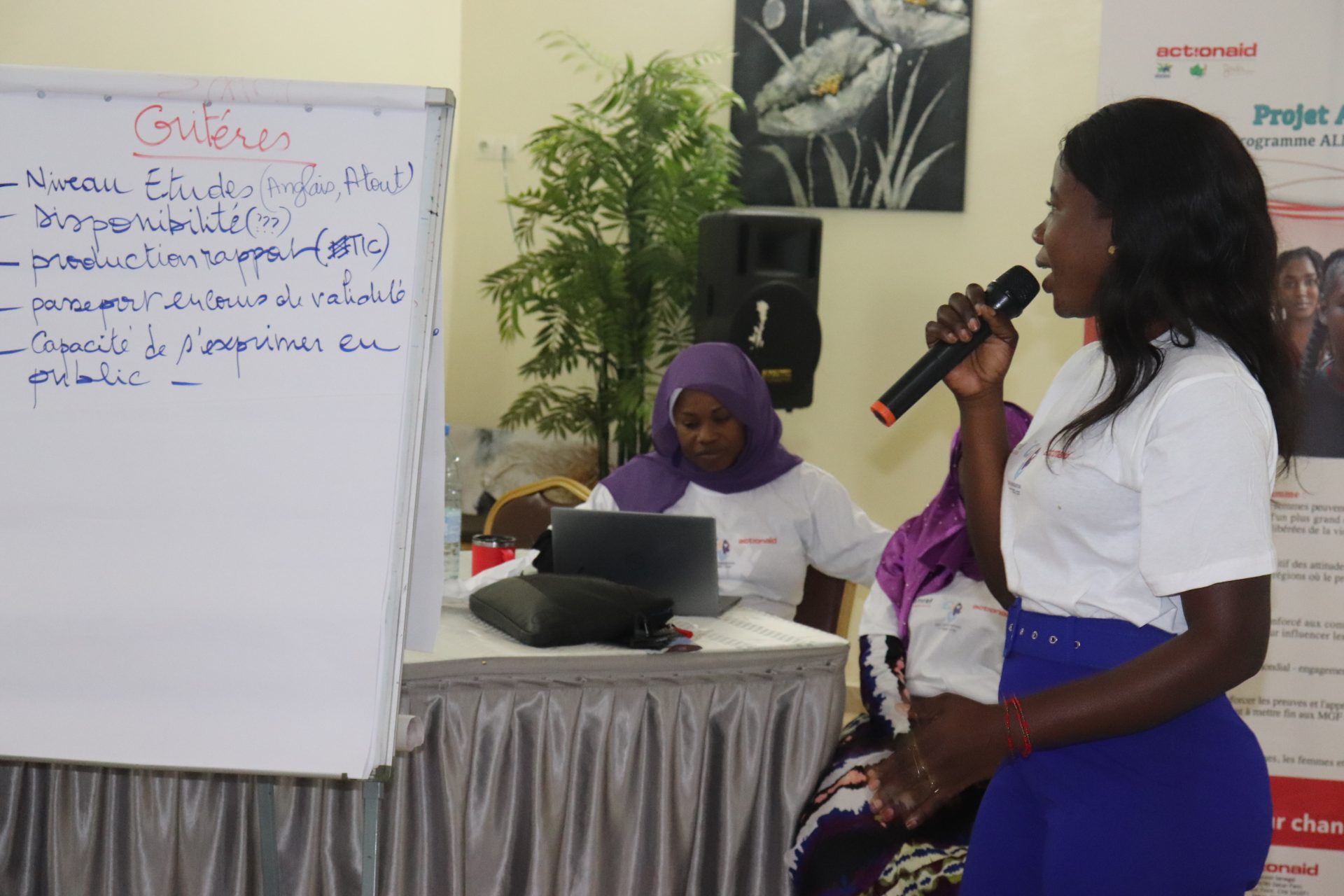 Ragazza del Senegal parla al microfono di fronte a una lavagna